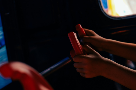 Close up on kid hands playing behind the wheel of a game console background. Electronic business entertainment activity. Playful education simulation technologyの写真素材