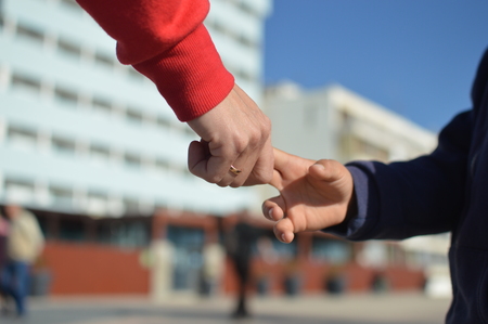 Close up on hand of mother and child on sunny outdoors background. Happy assistance, healthy motion togetherness. Human love, relation, protection and support. Holding emotional connection.の写真素材