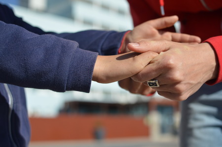 Close up on hand of mother and child on sunny outdoors background. Happy assistance, healthy motion togetherness. Human love, relation, protection and support. Holding emotional connection.の写真素材
