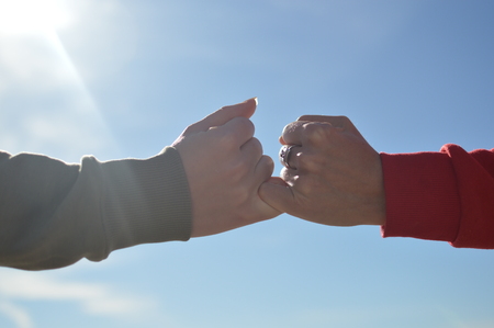 Close up on hand of mother and child on sunny outdoors background. Happy assistance, healthy motion togetherness. Human love, relation, protection and support. Holding emotional connection.の写真素材
