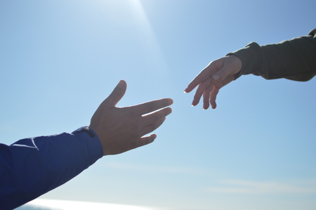 Touching human hands of cheerful people on sunshine beautiful nature outdoors. Lovely valentine harmony, symbolic friendship help. Closeup lifestyle support, dreams holiday travel freedom vacationの写真素材
