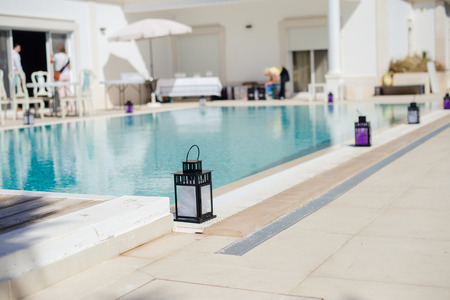Candle lantern near the pools edge on a summers day, Portugal
