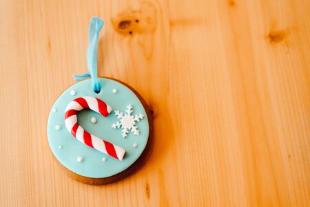 Sweet Ginger bread cookie on the wooden table background near the white Christmas tree with golden bokeh lightsの写真素材