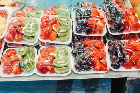 Fruit Salad arranged in plastic cups on a market stall with small fork inside, takeaway snackの写真素材