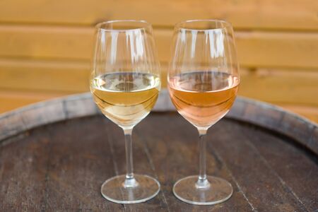 Wine glasses with white and rose wines on the cork tableの写真素材