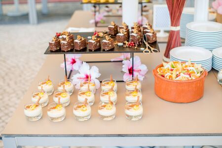 The catering wedding buffet for events. Wedding reception dessert table with delicious decorated white cupcakes with berries closeup.の写真素材