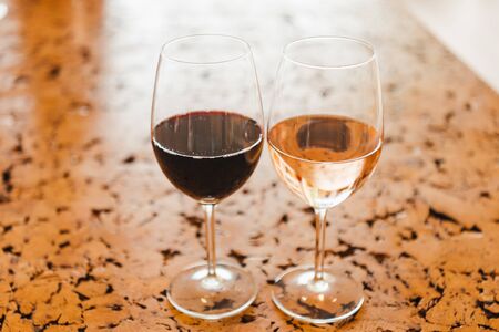 Wine glasses with red and rose wines on the cork tableの写真素材