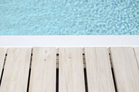 Swimming pool with blue water and wooden white side backgroundの写真素材