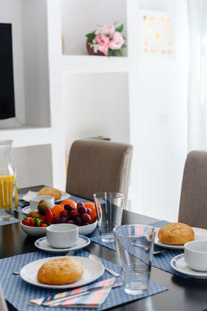Plate with toasted bread and glass of juice on grey background, top view