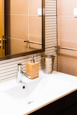 Ceramic Water tap sink with faucet with soap and shampoo dispensers in expensive loft bathroom