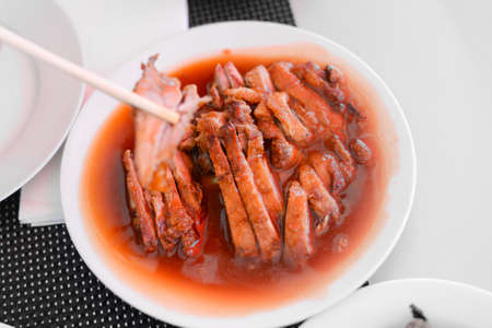 Roasted duck with Sauce, Chinese style on a white plate in buffet restaurantの写真素材
