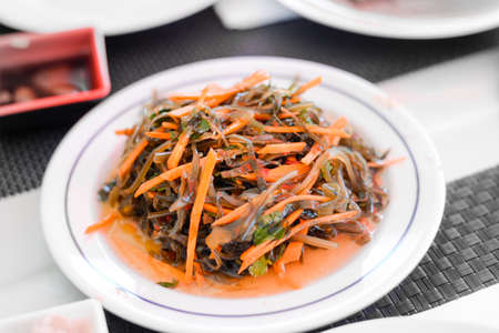 traditional Seaweed Salad with Carrot on white plate in chinese buffet restaurantの写真素材