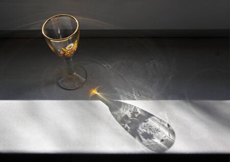 Still life on the windowsill of wine glass for spirits drinksの写真素材
