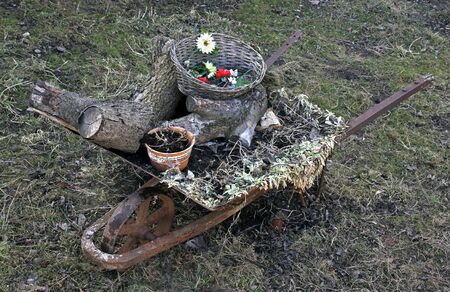 Wheelbarrow with household rubbish, weeds and firewoodの写真素材
