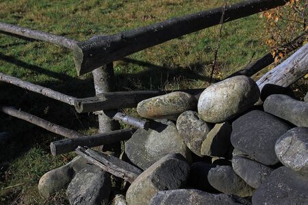Large oval stones under a wooden fenceの写真素材