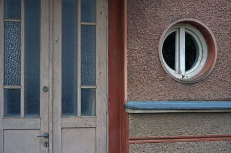 Beige facade with old door and a rounded windowの写真素材