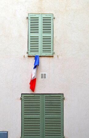 France flag hanging from window of old houseの写真素材
