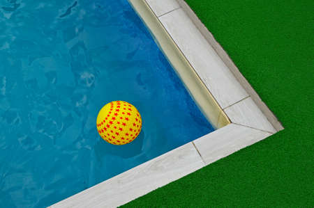A yellow asterisk ball floats on the surface of the water in the pool