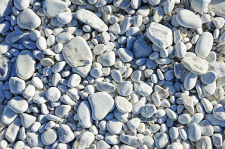 Different sized oval and round marble pebbles on the coast of the Ligurian Sea near Pisa in Italy