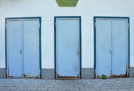 Three partially rusted metal blue doors with mortise locksの写真素材
