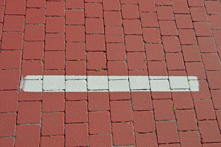 White road markings on square terracotta cobblestonesの写真素材