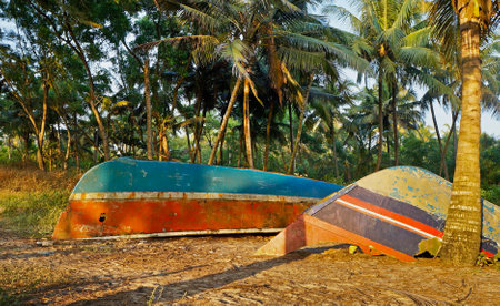 Two abandoned boats on Marari sandy beach near Kochi in Kerala, Indiaの写真素材
