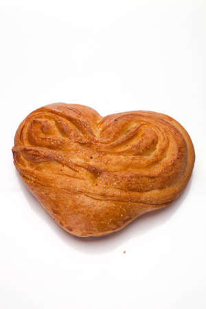 sweet bun in heart shaped form on whiteの写真素材