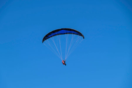 Paragliding with clear blue sky background