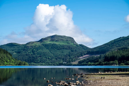 Tree covered mountains reflected in Loch Lubnaig, Scotlandの写真素材