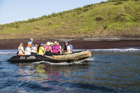 Galapagos Islands, Ecuador - February 7, 2016: Passengers of Silver Galapagos, a luxurious Silversea expedition cruise ship, enjoy an excursion on an inflatable boat watching for wildlife and spot a sea lion lying on the beach.のeditorial素材