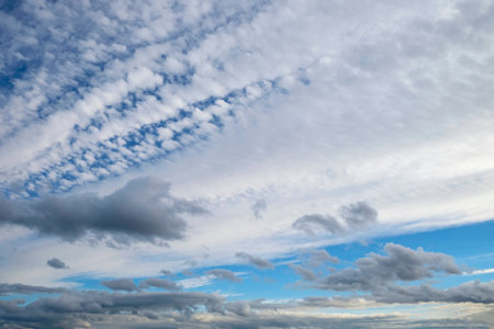 Beautiful summer cloudscape as gray and white clouds fan across a blue sky