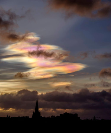 Edinburgh skyline silhouetted against early morning sky with beautiful rare nacreous clouds.の写真素材