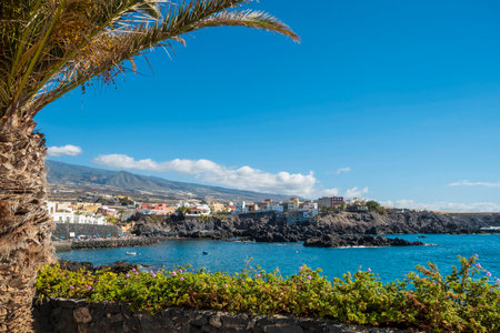 Pretty Tenerife seaside town of Alcala above the rocks and cliffs beside clear turquoise waters of the Atlanticの写真素材