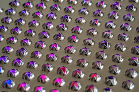 Abstract macro closeup of the holes of stainless steel cheese grater with colored lights shining...