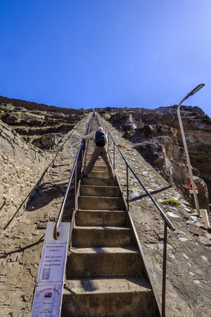 ST HELENA ISLAND, SOUTH ATLANTIC - APRIL 2 2018: Photographer stands astride the 699 steps of Jacobs Ladder in Jamestown taking photos of tourists on their way downのeditorial素材