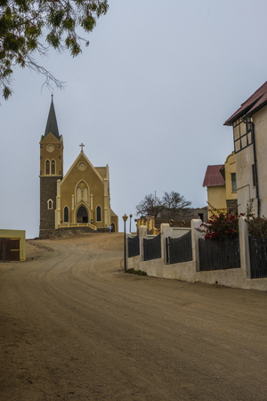 LUDERITZ, NAMIBIA - MARCH 23 2018: Looking up street in Luderitz to iconic Evangelical Lutheran Felsenkirche, the church on the rocks, highest place in the Namibian town, consecrated in 1912.のeditorial素材