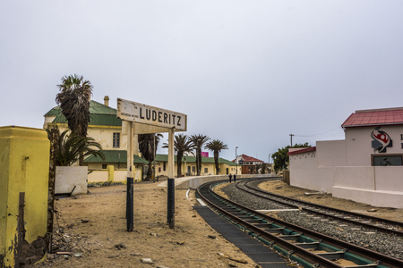 LUDERITZ, NAMIBIA - MARCH 23 2018: Two people in the distance walking along rail tracks at Luderitz Railway Station, part of TransNiamib Railway and built in 1904のeditorial素材