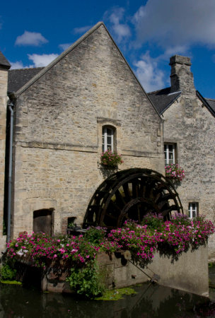 An old water mill with a wooden wheel in its facade in Bayeuxの写真素材