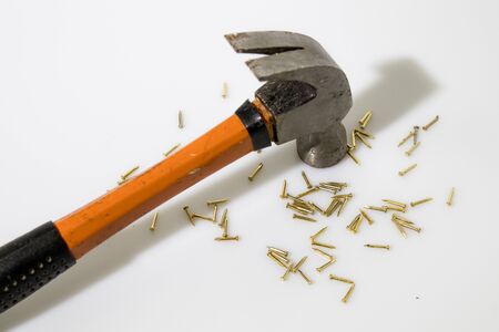 Hammer and gold tacks in a white backgroundの写真素材