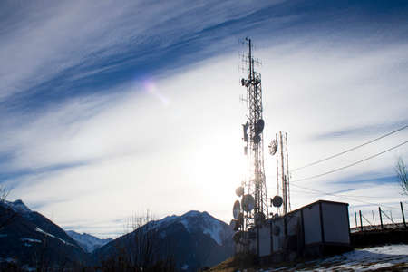 Telecommunication tower in a blue sky and cloudsの写真素材