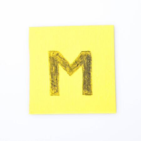 M alphabet letter handwrite on a yellow paper compositionの写真素材