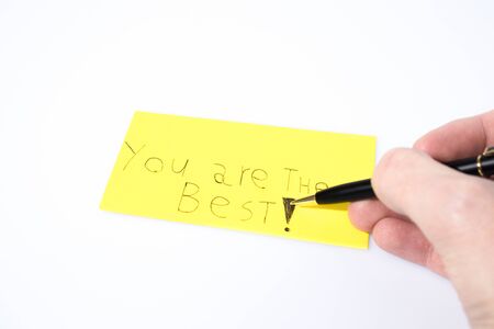 You are the best handwrite with a hand and a pen on a yellow paper compositionの写真素材