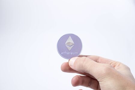 Cryptocurrency hand is holding an etherum in a composition