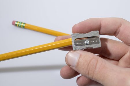 Temper a pencil and a hand in a white background compositionの写真素材