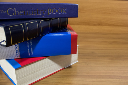 School, a pile of colored books on a wood table composition