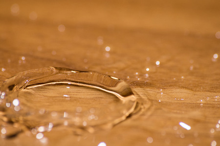 Shining drop of water colored of orange isolated compositionの写真素材