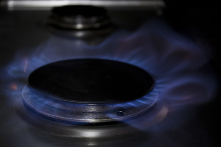 Gas cooker and blue flames in a kitchen with black shadows composition