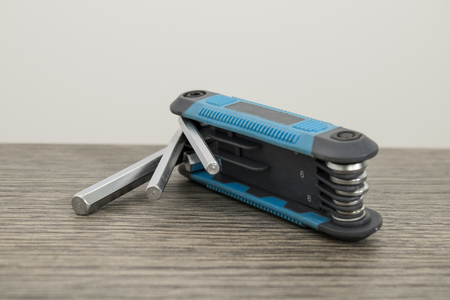 Blue multitool allen keys on a decorated wood table composition