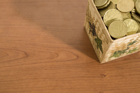 Box full of euro coins on a wood table composition