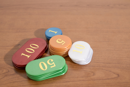 Colored casino chips on a wood table compositionの写真素材